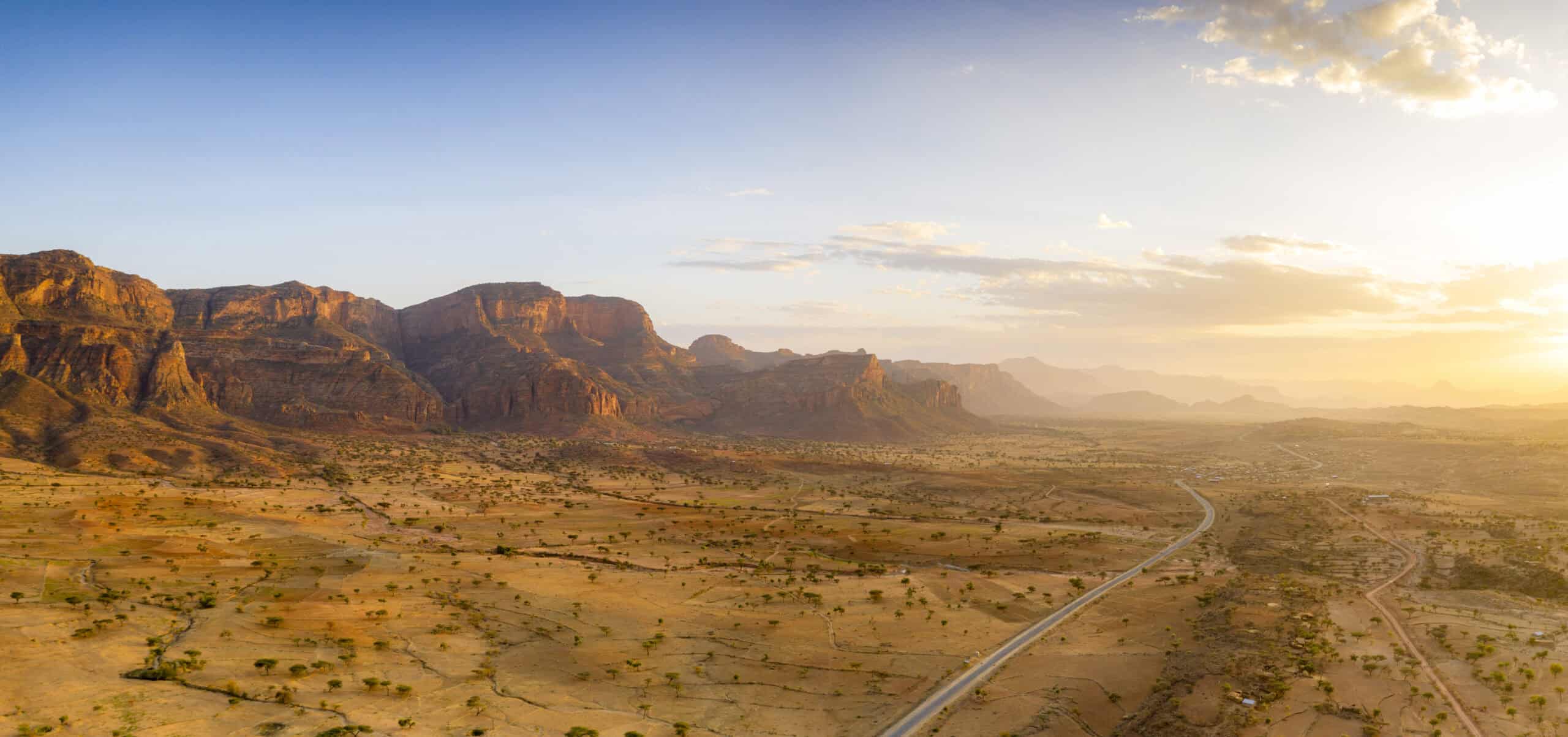 Sunset lit the empty road crossing the dry land of Gheralta Mountains, Ethiopia