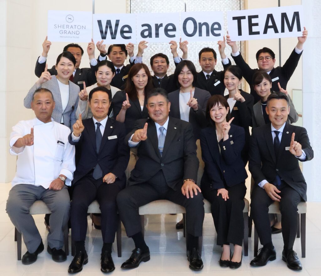 A Director of Sales & Marketing posting for a group photo with her team.