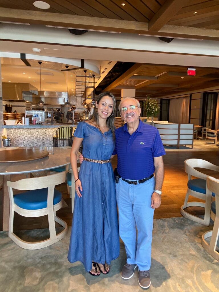 Sandra, Director of Finance, standing in front of a restaurant.
