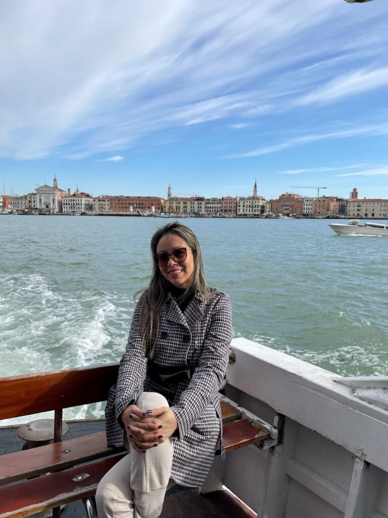Sandra, Director of Finance, sitting on a boat in front of a city.